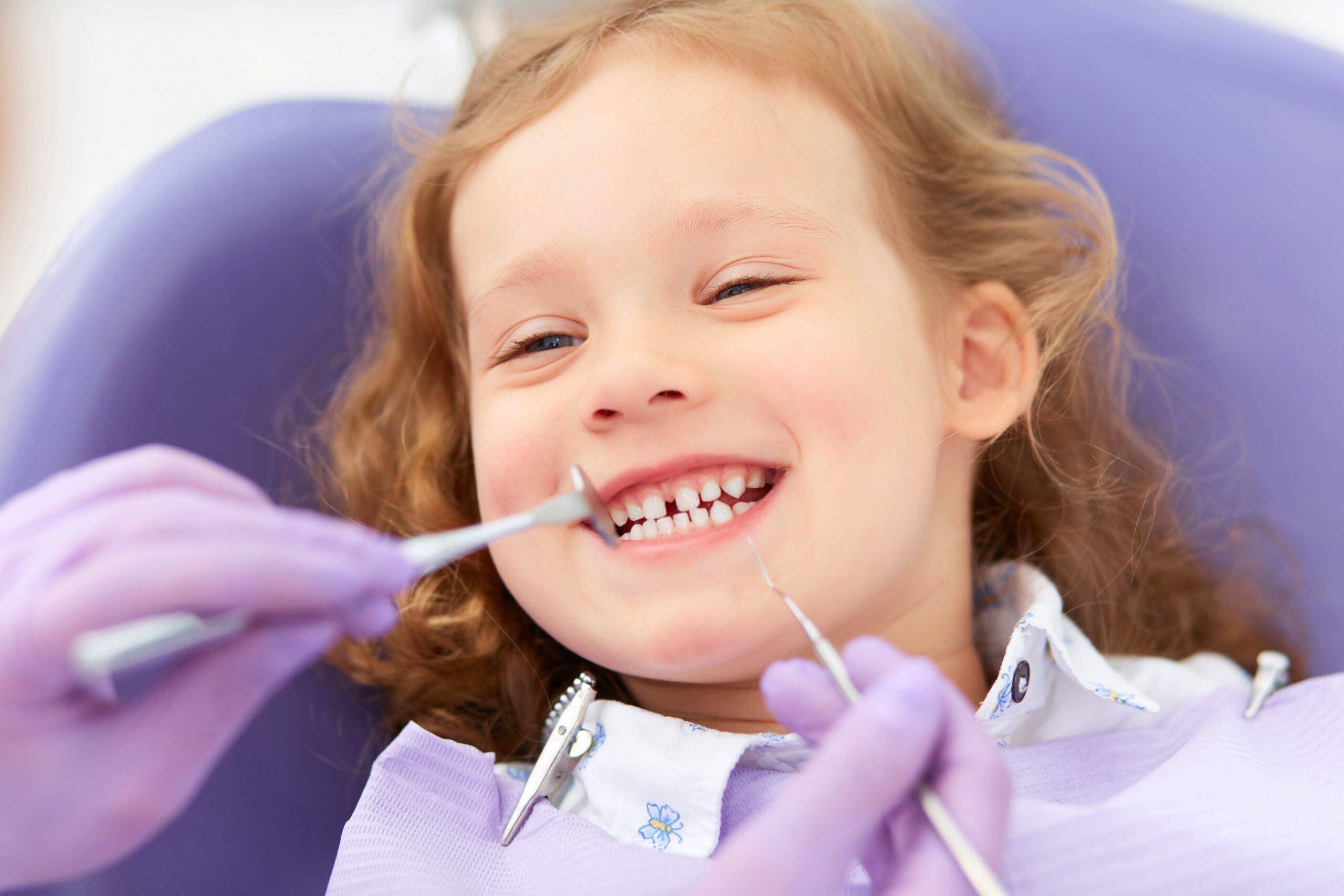 child at a pediatric dentist visit smiling.